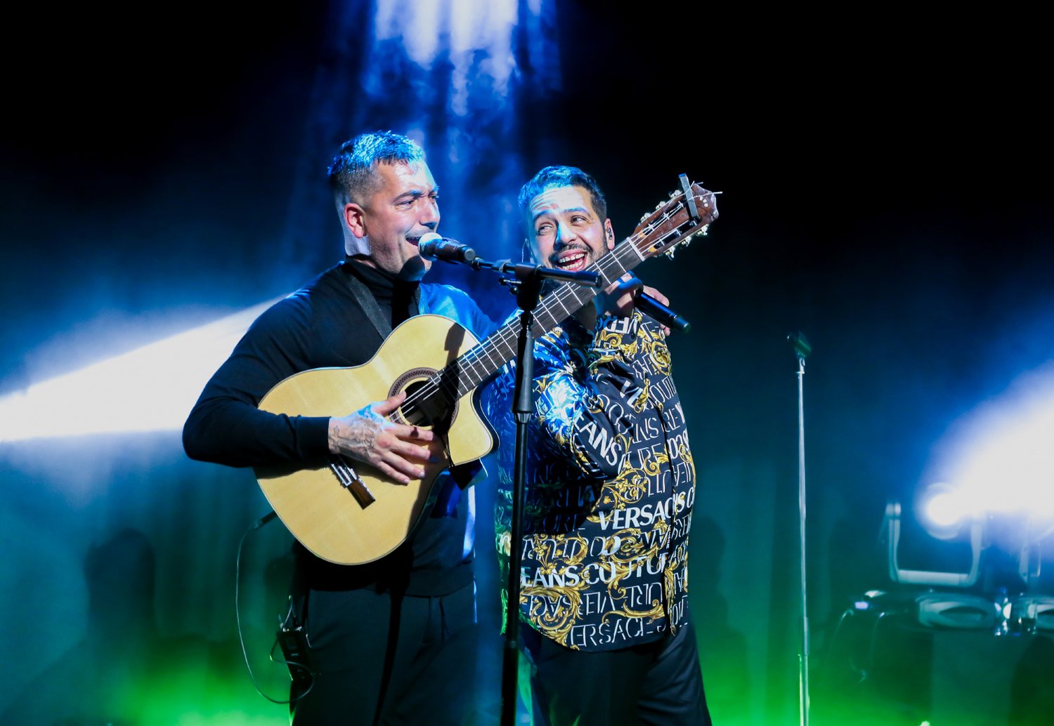 Janah Louard zingt naast zijn gitarist in blauw podiumlicht